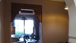 A room with a dining table and chairs, a sofa set, and a window with curtains. - A haven of peace in the heart of the palm grove (Marrakech)
