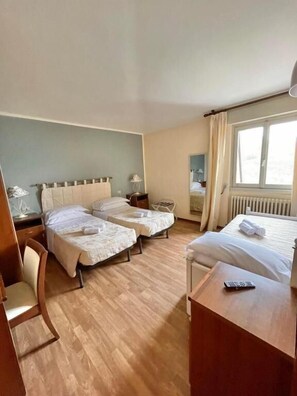 A hotel room with two beds, a desk, a chair, and a window. - Hotel La Sorgente (Plesio)
