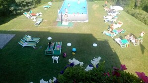 A pool area with multiple lounge chairs and a small inflatable pool surrounded by grass. - Hotel La Sorgente (Plesio)