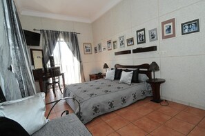 A bedroom with a bed, bedside tables, a desk, and a chair. - Hôtel de la Poste (Saint-Claude)