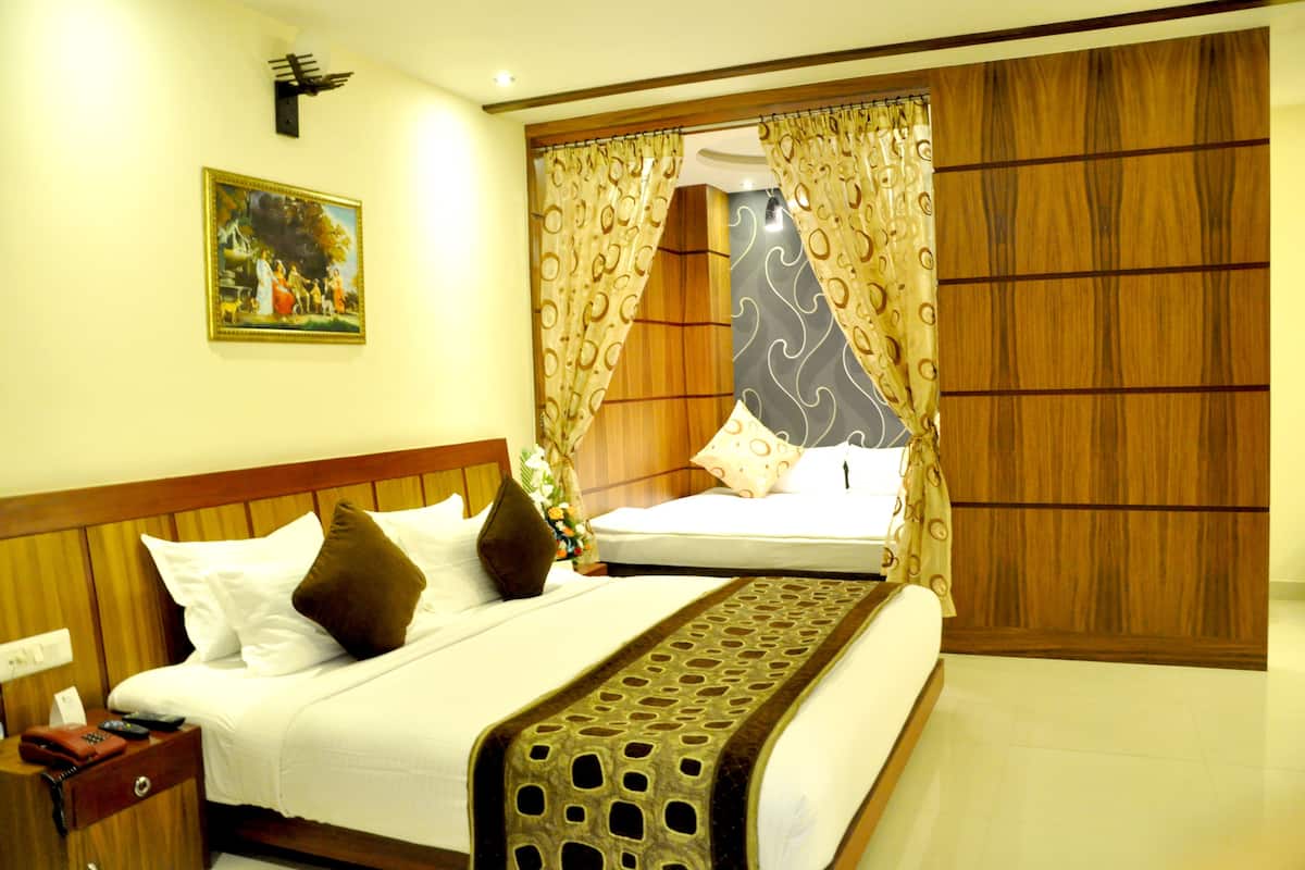A hotel room with a bed, a nightstand, a painting on the wall, and curtains.