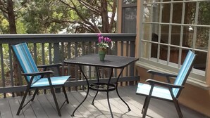 A wooden deck with a table and two chairs.