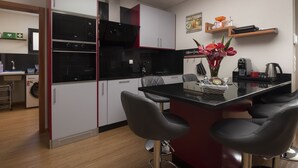 Cocina moderna con una isla central, taburetes de bar y un jarrón decorativo.