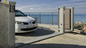 Un coche blanco estacionado frente a un edificio con un letrero que dice "Santa Catalina House Madeira No 13".