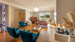 A modern living room with teal chairs, a pink sofa, and a piano. - Villa Modigliani - Casarano (Casarano)