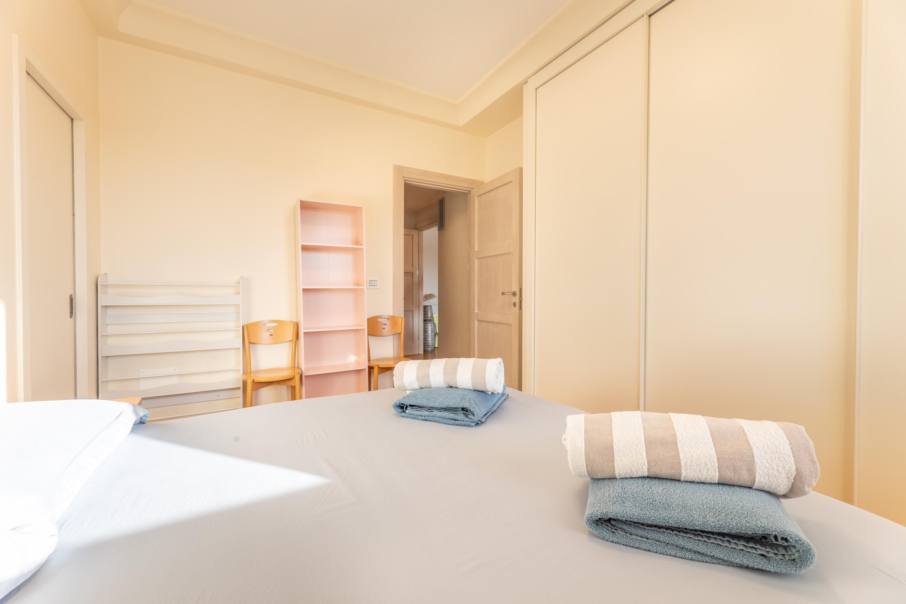 Une chambre à coucher comprenant un lit, une chaise, une armoire et une étagère.