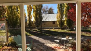 A stone patio with scattered pumpkins, a green chair, and a table. - Hollyhock House in Spring City (Spring City)