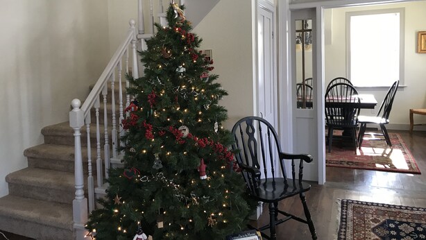 A staircase with a Christmas tree decorated with lights and ornaments. - Hollyhock House in Spring City (Spring City)