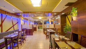 Un restaurante con paneles de madera, iluminación moderna y un pasillo central.