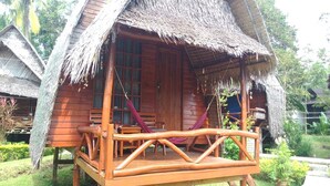A wooden cabin with a thatched roof, a porch with a hammock, and a small deck. - Lanta Marina Resort (Ko Lanta)