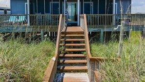 Une maison avec un escalier en bois menant à une véranda.