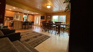 A cozy cabin interior with a kitchen, dining area, and living room. - The Best Kenai Peninsula Base Camp. (Sterling)