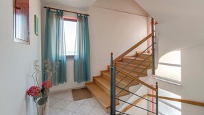 Una escalera de madera con barandillas de metal, que conduce a un piso superior.