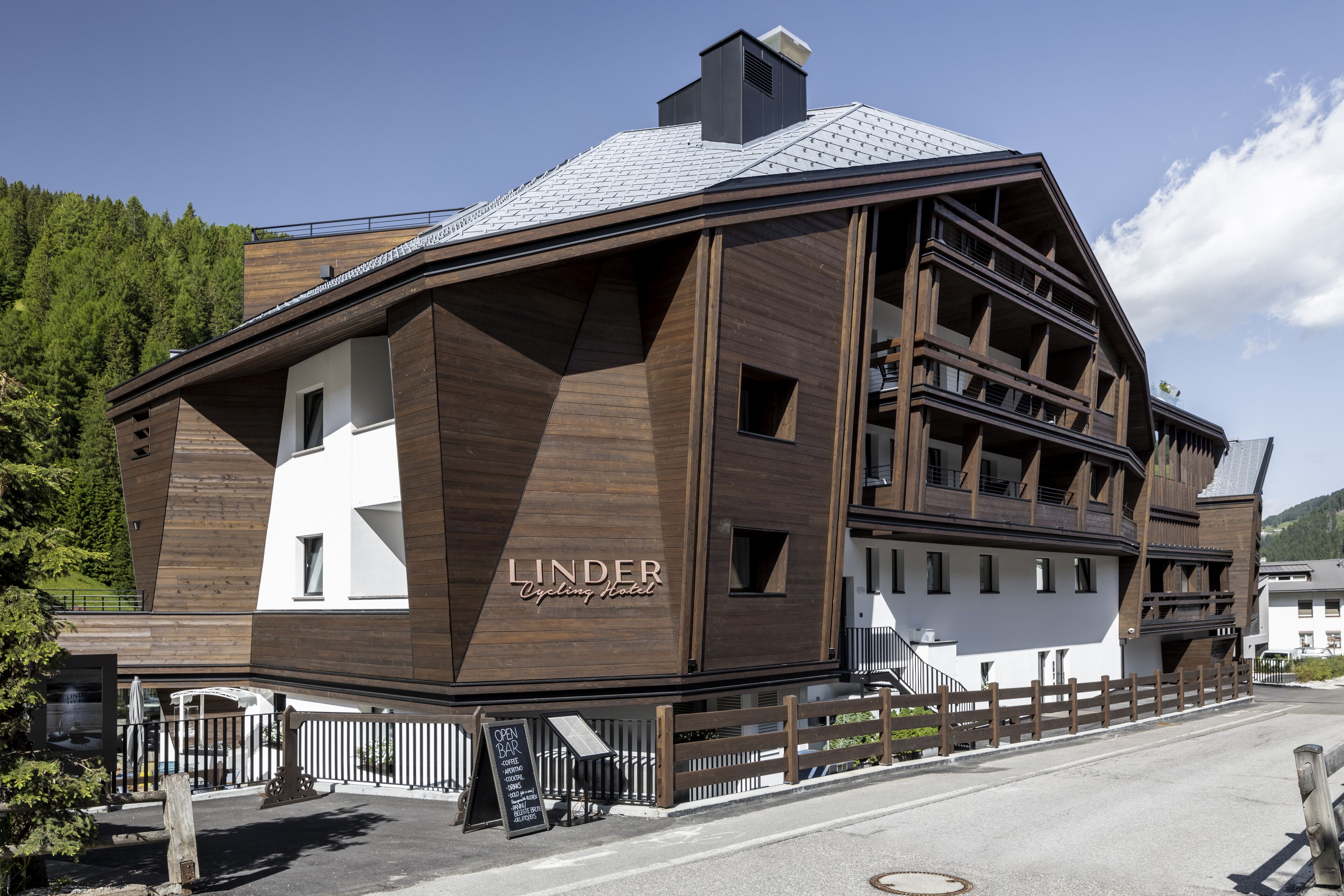 Un Hotel Linder Cycling con diseño moderno, destacando una fachada principal de madera y un área de balcón.