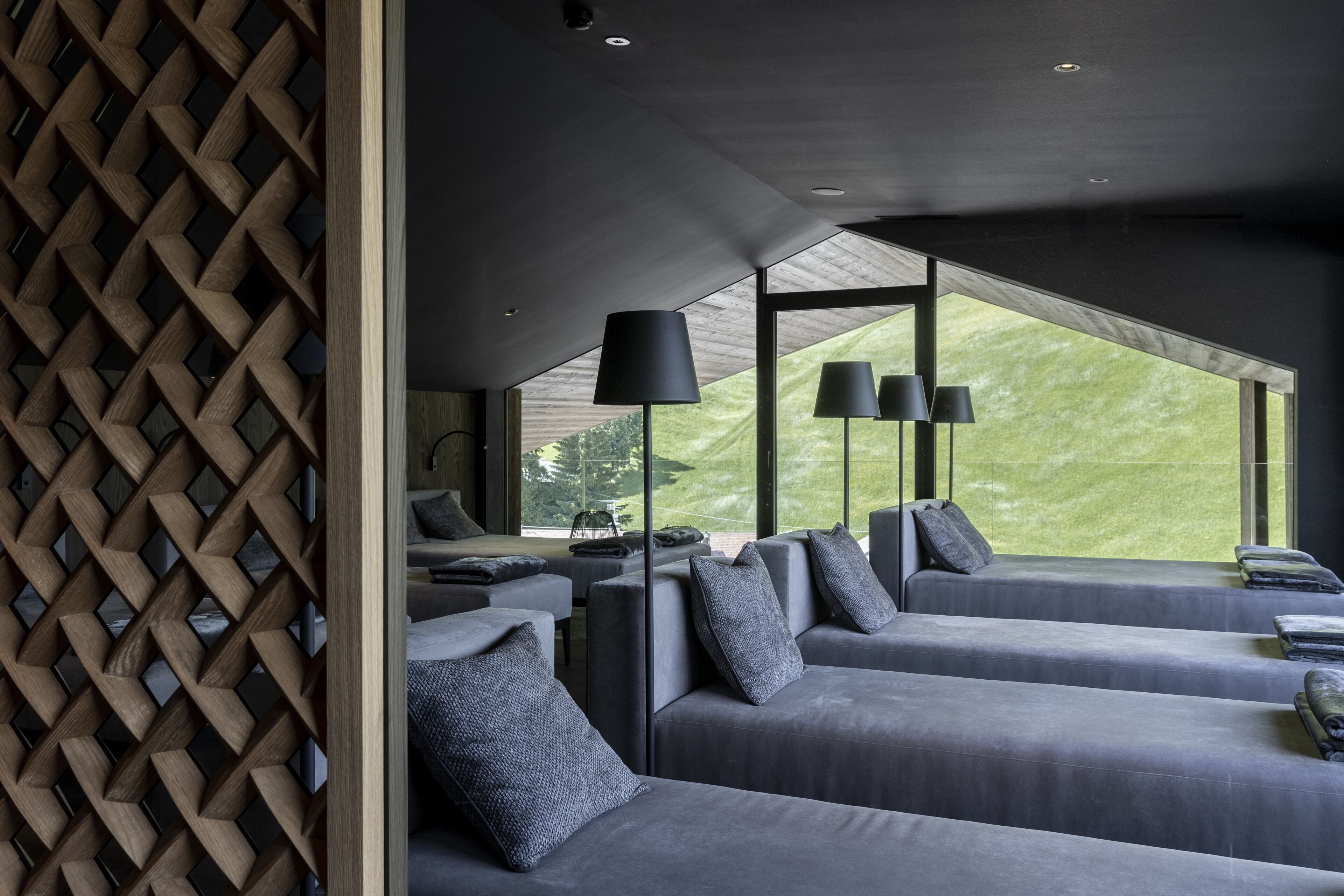 Une chambre d’hôtel moderne avec un plafond haut, de grandes fenêtres et une vue sur l’extérieur.