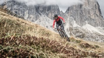 A mountain biker on a trail with rocky terrain and steep inclines.