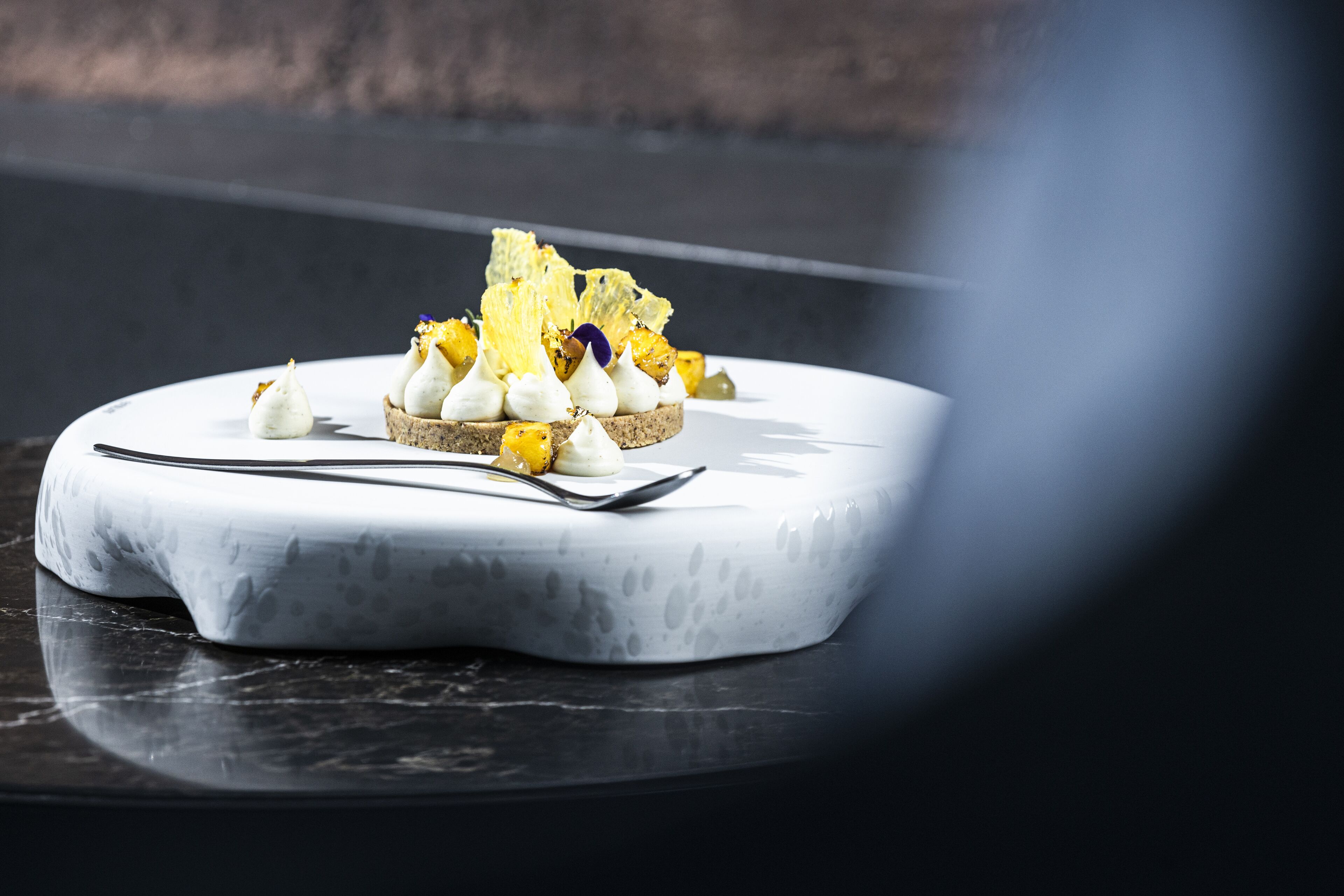 A dessert on a white, oval-shaped plate with a marble background.