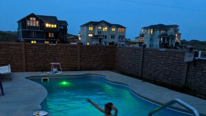 A swimming pool with a curved edge, surrounded by a brick wall. - FamilyMemoryMaker!,8 MASTERS,MovieRoom,OceanViews,Pool,HotTub,Grill,StarlinkWiFi (Corolla)