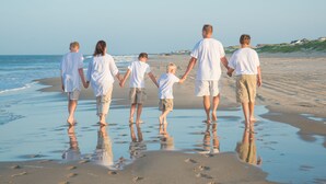 A family walking on a sandy beach with calm waves. - FamilyMemoryMaker!,8 MASTERS,MovieRoom,OceanViews,Pool,HotTub,Grill,StarlinkWiFi (Corolla)
