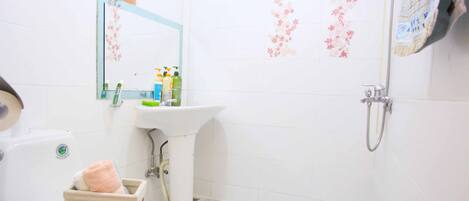 Un baño con inodoro, lavamanos y ducha.