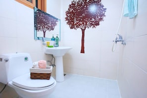 A bathroom with a toilet, sink, and shower.