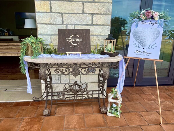 A table with a sign that reads 'Crawford 10.22.22' and a floral arrangement on a stand. - PermaVista Ranch & Resort- Experience A Luxury Texas Ranch (Brenham)