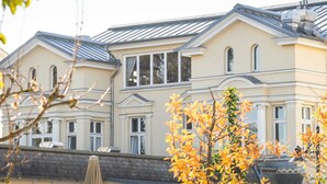 A two-story building with a symmetrical facade, large windows, and a flat roof.