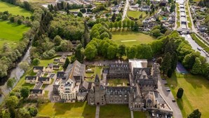 An aerial view of a large, historic estate with a central castle-like structure, surrounded by manicured gardens and residential buildings. - 9 THE MONASTERY WITH LOCH NESS VIEWS - sleeps 4 guests  in 2 bedrooms (Fort Augustus)