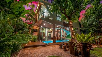 Experience the serene atmosphere of this multi-level building, surrounded by lush greenery and a tranquil pool area.