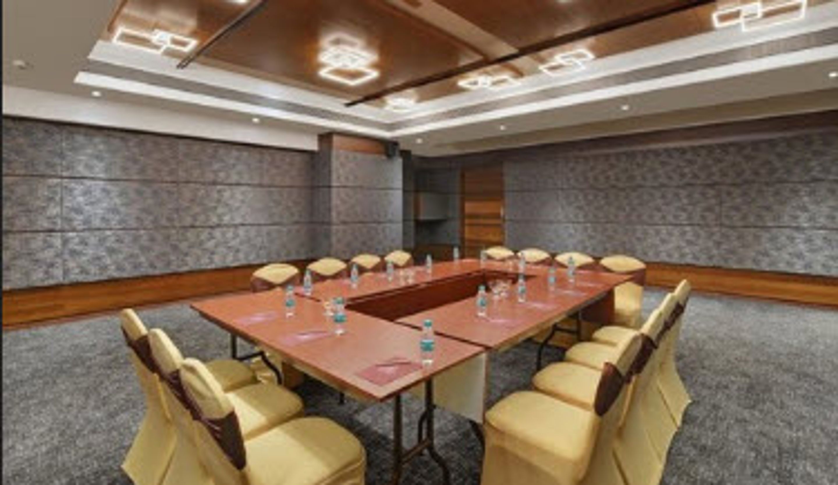A conference room with a long table, multiple chairs, and water bottles on the table.