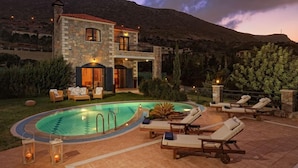 A two-story stone house with a swimming pool, outdoor seating, and a mountainous backdrop. - Villa Erato / Private Paradise with heatable Pool &   Sea View. (Koutouloufari)