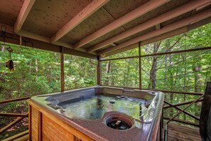 A hot tub in a wooden cabin with a view of a forest. - Perfect mountain cottage ☎ Fire pit ☎ Gas Fireplace ☎ Screened Porch ☎ Secluded (Townsend)