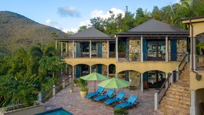 A two-story building with a pool, lounge chairs, and a staircase leading to the upper level. - Francis Bay Estate: Luxury Villa! Pool! Walk To The Beach! (Mary Point)