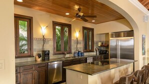 A kitchen with wooden ceiling, a central island, stainless steel appliances, and a view of greenery outside. - Francis Bay Estate: Luxury Villa! Pool! Walk To The Beach! (Mary Point)