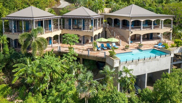 A large, multi-story house with a swimming pool, multiple balconies, and lush greenery surrounding the property. - Francis Bay Estate: Luxury Villa! Pool! Walk To The Beach! (Mary Point)