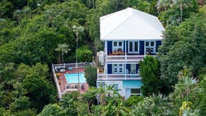 Ein zweistöckiges Haus mit Swimmingpool und Balkon.
