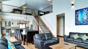 A spacious living area with a staircase, a dining area, and a kitchen. - Luxury cottage, panoramic view over the entire valley/Ski Resort, 24 people (Stoneham-et-Tewkesbury)