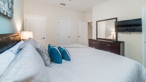 Relax in this inviting space with a large bed, dresser, and flat-screen TV.