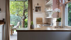 Een moderne keuken met een houten aanrecht, een ingebouwd spoelbak en een raam met uitzicht op een boom.