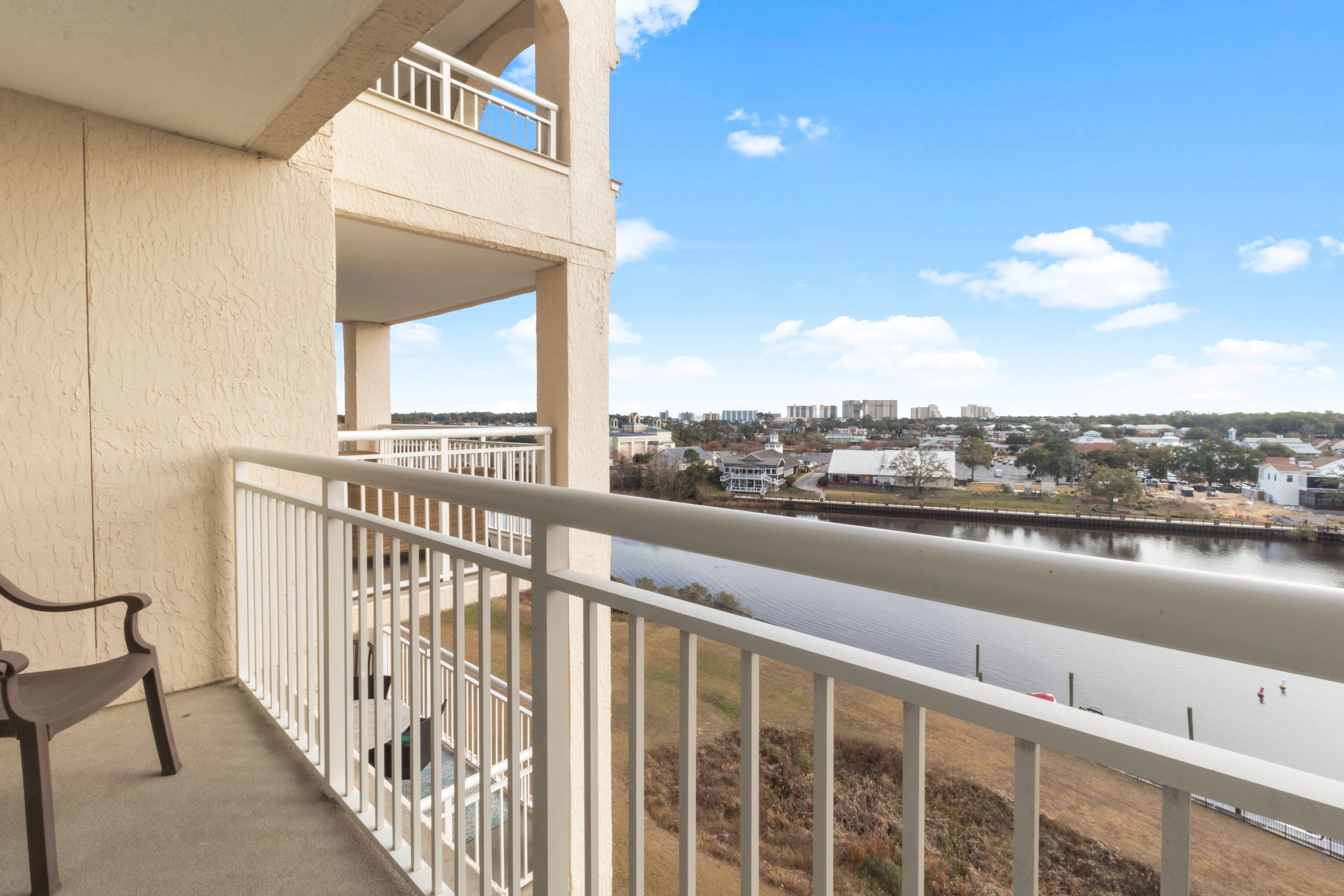 A balcony with a view of a river and cityscape.