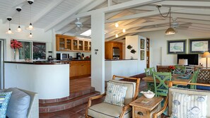 A spacious living area with a kitchen, dining table, and seating.