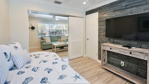A bedroom with a bed, a TV, and a wooden console. - Blue Pearl for 10-Heated Pool-Beach-Pier 5 minutes (Pompano Beach)