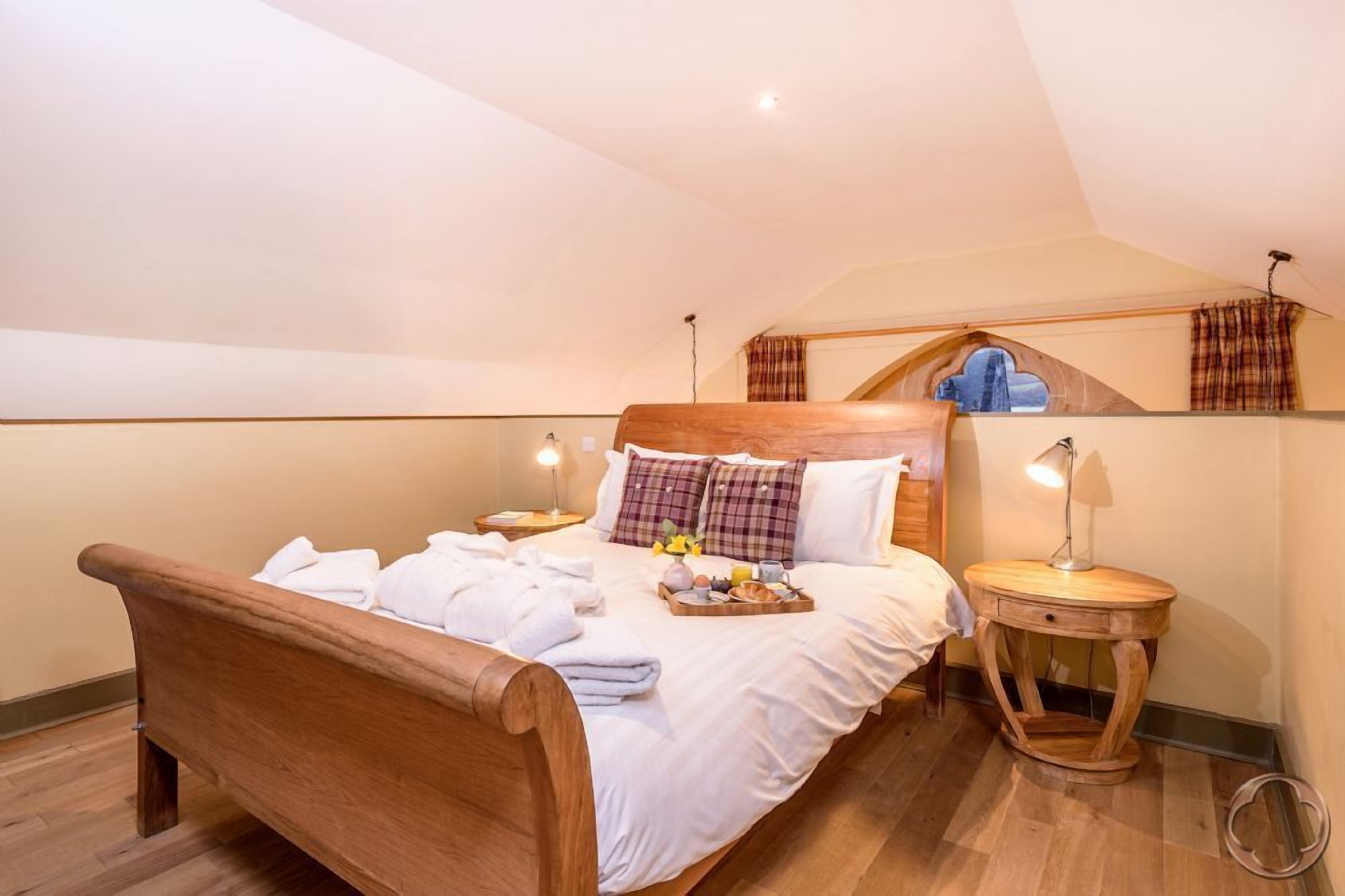 A cozy bedroom with a wooden bed, a small bedside table, and a nightstand.