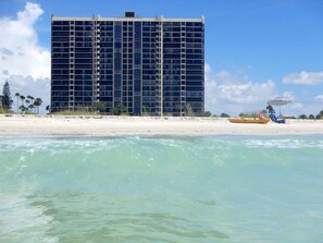 Hotel à beira-mar com um edifício grande, praia de areia e vista para o oceano.