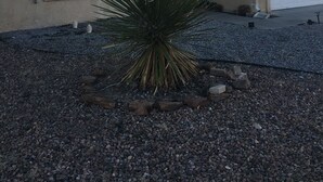 A house with a stucco exterior, a window, and a garage. - Relaxing/cozy home near Petroglyphs (Albuquerque)