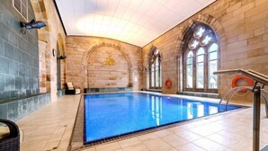 An indoor swimming pool with stone walls and arched windows. - Luxury self catering cottage with swimming pool  in the grounds of a Monastery on Loch Ness (Fort Augustus)