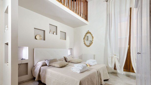 Una camera da letto con due letti, un grande specchio e vista sull'esterno.