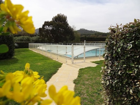 Una piscina al aire libre, sillones reclinables de piscina