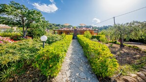 Ein Weg führt zu einem Gebäude mit Garten und blauem Himmel.