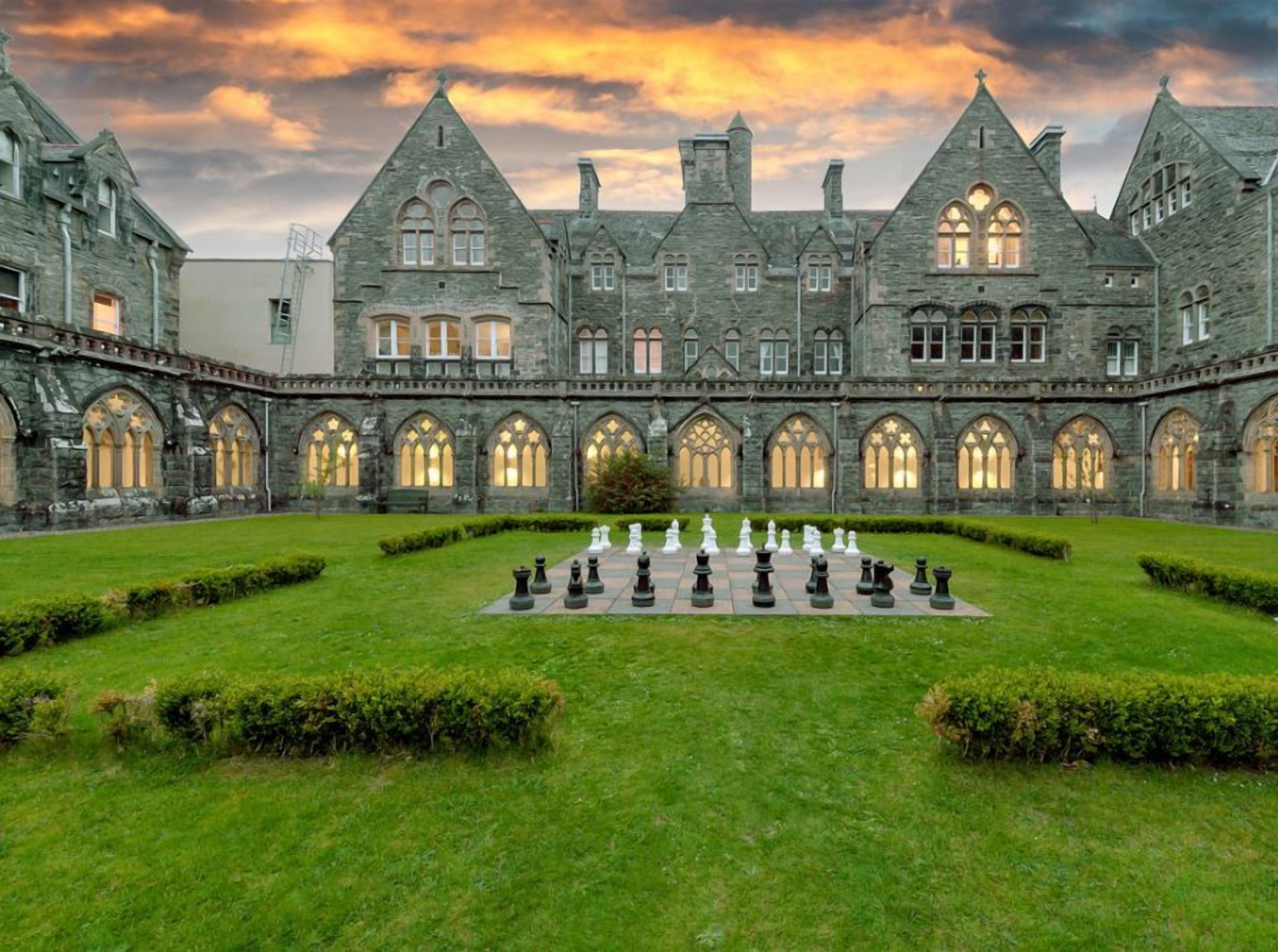 A historic building with a courtyard featuring a chessboard.